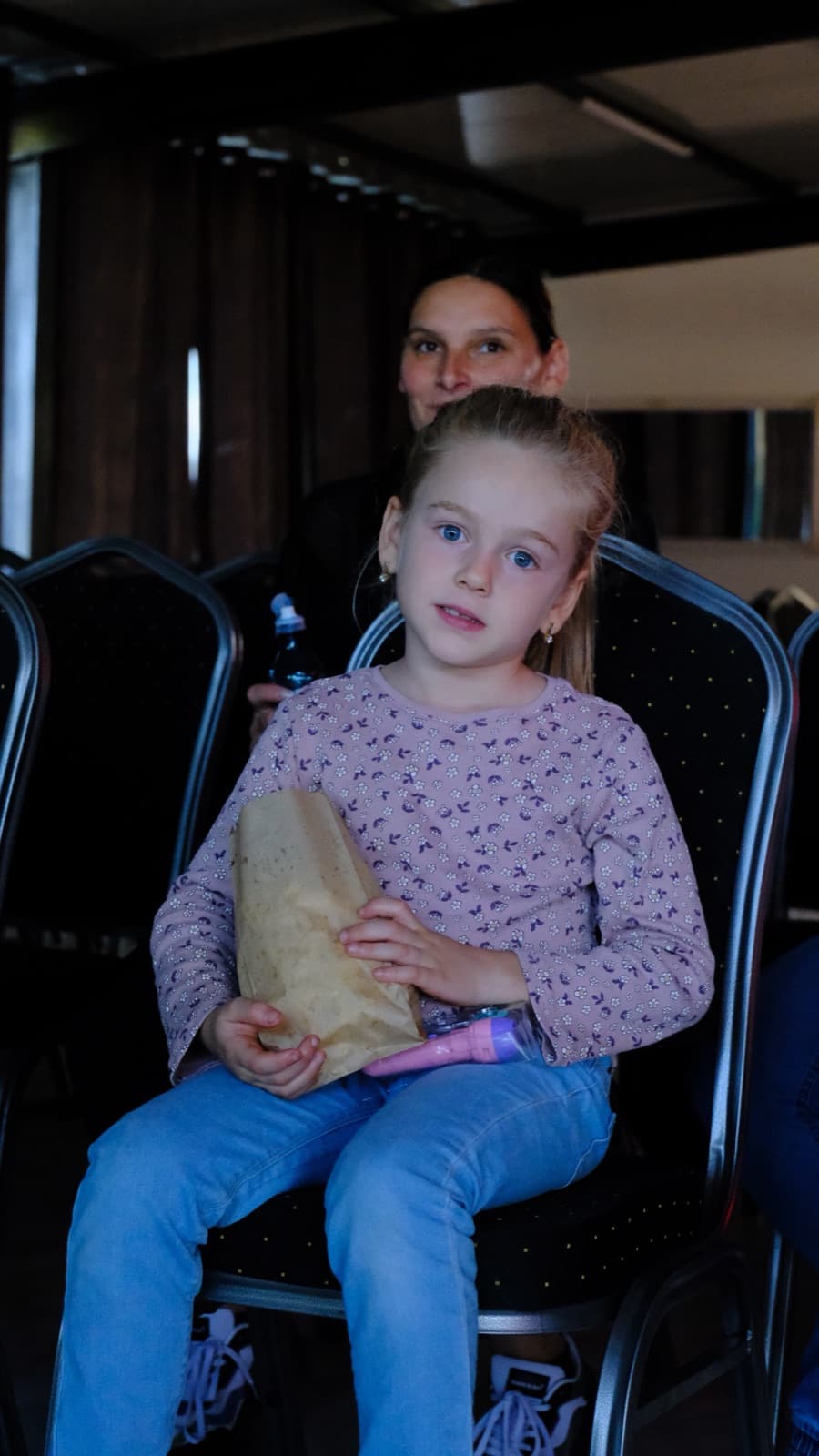 O fetiță cu popcorn, pe rândul din față